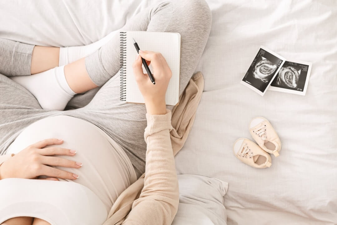 pregnant woman preparing for labor sitting on bed